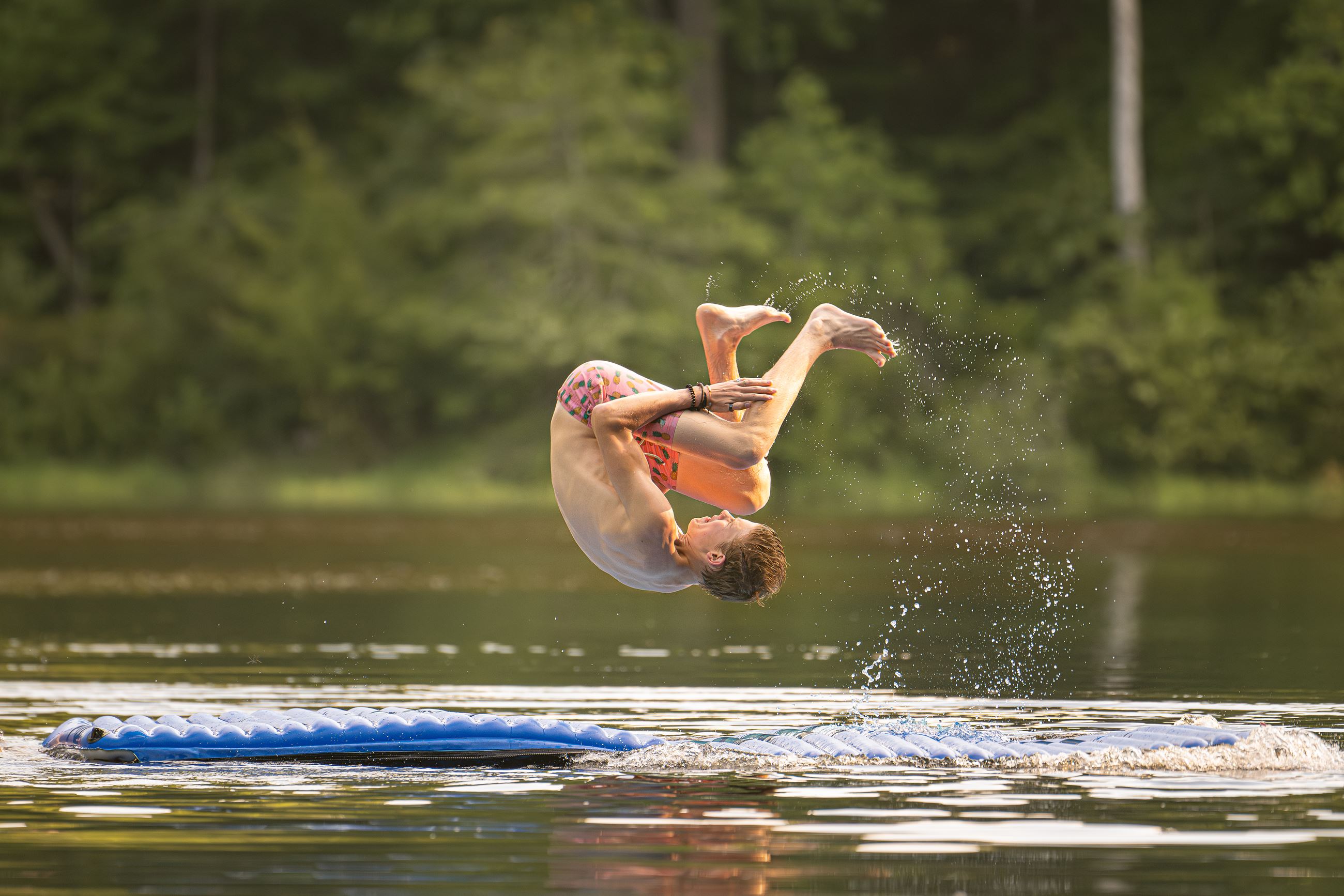 Kid doing a back flip into the river