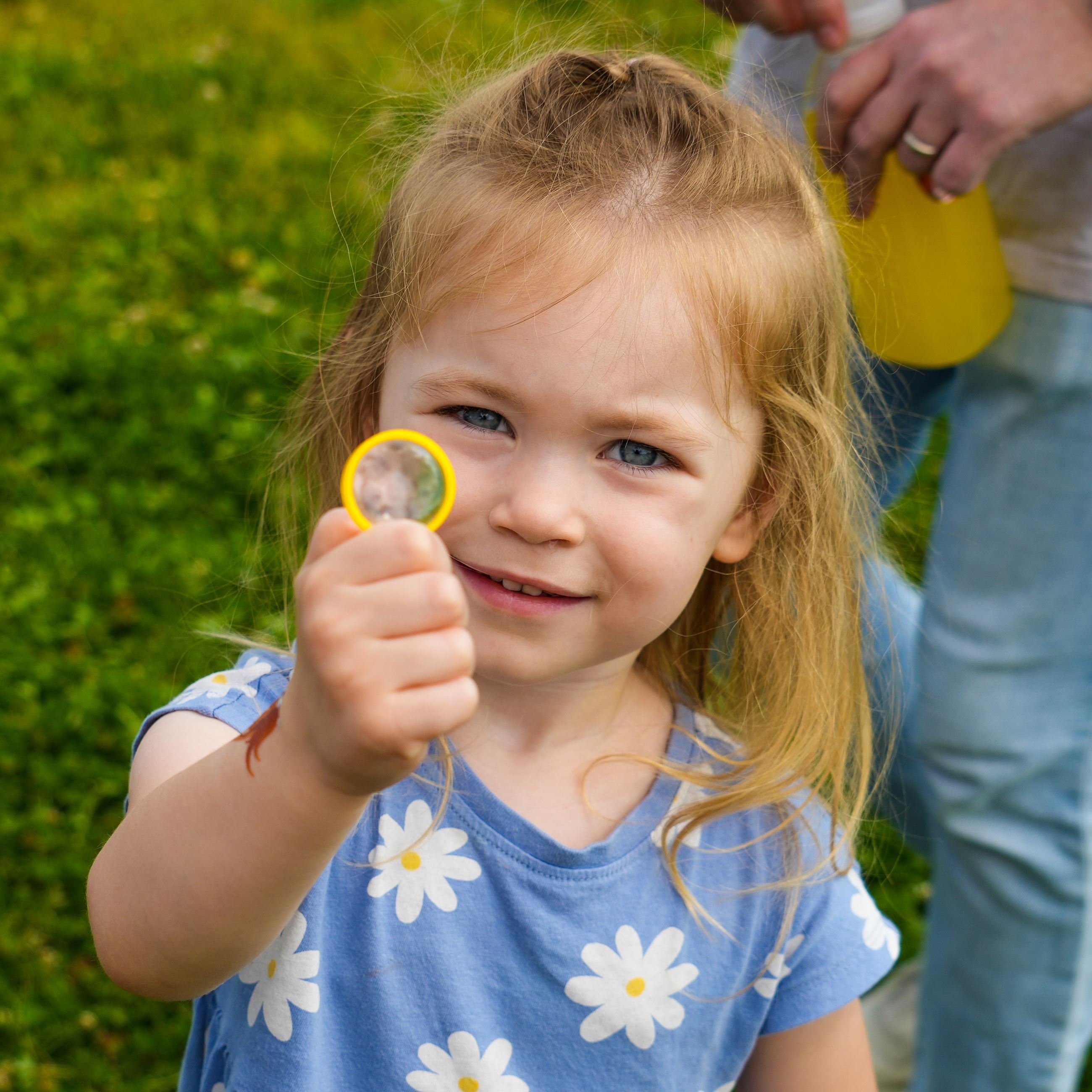 A kid posing with a toy magnifying glass